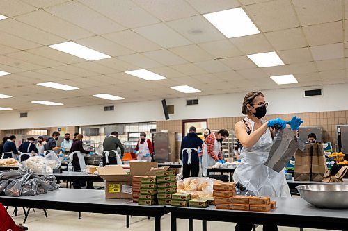 Volunteers prepare free holiday meals for Westman and Area Traditional Christmas Dinner deliveries Saturday at Crocus Plains Regional Secondary School. (Chelsea Kemp/The Brandon Sun)