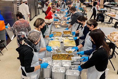 Volunteers prepare free holiday meals for Westman and Area Traditional Christmas Dinner deliveries Saturday at Crocus Plains Regional Secondary School. (Chelsea Kemp/The Brandon Sun)