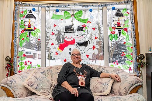 Genevieve Howard showcases her hand painted Christmas window art Thursday at her home. (Chelsea Kemp/The Brandon Sun)
