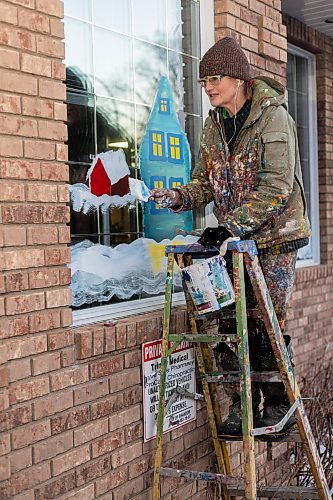 Artist Anne Bondamann creates a Christmas window painting on Tuesday, Dec. 14.  (Chelsea Kemp/The Brandon Sun)