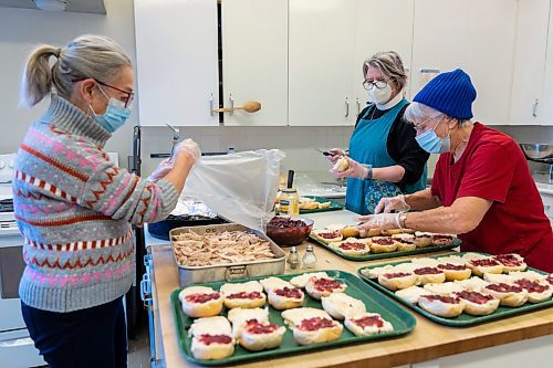 St. Matthew's Anglican Cathedral volunteers pack Christmas lunch bags Friday. (Chelsea Kemp/The Brandon Sun)