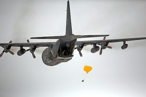 A soldier drops a parachute with a payload out the rear cargo door of a C-130 Hercules aircraft as it flies over the Brandon Municipal Airport on Monday during a routine training session by members of 435 Transport and Rescue Squadron, which are based out of 17 Wing Winnipeg. (Matt Goerzen/The Brandon Sun)