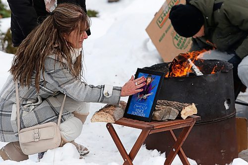 JOHN WOODS / WINNIPEG FREE PRESS
A woman touches a photo as just before putting tobacco in a fire at a memorial/celebration of life for musician Vince Fontaine at Oodena Circle at the Forks Sunday, January 16, 2022. 

Re: ?