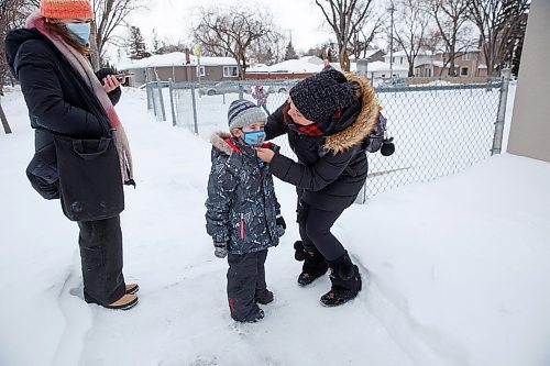 MIKE DEAL / WINNIPEG FREE PRESS
Tiffany Munro puts on a mask for her son Maverick, 5, as he heads to school Monday morning.
Parents drop off kids at Carpathia School, 300 Carpathia Road, Monday morning. 
See Maggie Macintosh story
220117 - Monday, January 17, 2022.
