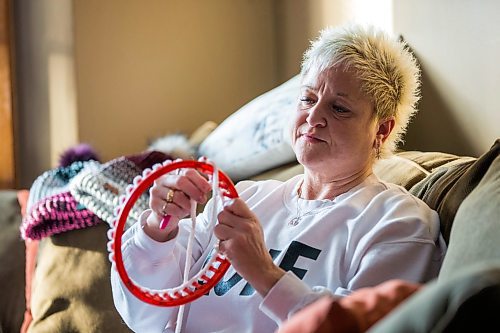 MIKAELA MACKENZIE / WINNIPEG FREE PRESS

Kyla Simms makes a toque in Winnipeg on Tuesday, Jan. 18, 2022. She is an armed forces veteran who has ptsd and, as therapy, was taught how to use a type of loom to make toques. She has since made so many she was able to give some to fellow patients and nurses at the health care facility in Ontario she was at and has recently donated 50 of them to Lighthouse Mission. For Kevin story.
Winnipeg Free Press 2022.