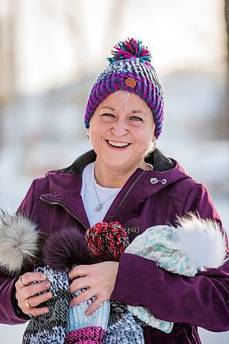 MIKAELA MACKENZIE / WINNIPEG FREE PRESS

Kyla Simms poses for a portrait with her toques in Winnipeg on Tuesday, Jan. 18, 2022. She is an armed forces veteran who has ptsd and, as therapy, was taught how to use a type of loom to make toques. She has since made so many she was able to give some to fellow patients and nurses at the health care facility in Ontario she was at and has recently donated 50 of them to Lighthouse Mission. For Kevin story.
Winnipeg Free Press 2022.