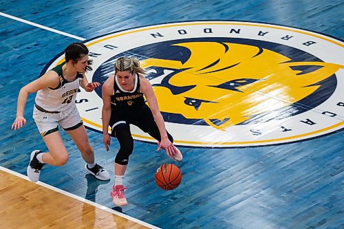 Chelsea Misskey of the Brandon University Bobcats drives the ball past the University of Regina Cougars Jade Belmore in a Canada West womenճ basketball game at the Healthy Living Centre Saturday. (Chelsea Kemp/The Brandon Sun)
