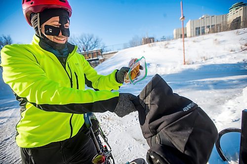 MIKAELA MACKENZIE / WINNIPEG FREE PRESS

Daniel Perry, who recently finished a 160 mile winter endurance cycling race, dumps snacks into his pogies in Winnipeg on Wednesday, Jan. 19, 2022. For Ben Waldman story.
Winnipeg Free Press 2022.