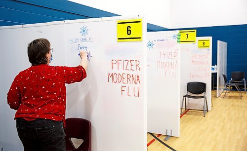 MIKE DEAL / WINNIPEG FREE PRESS
Retired nurse, Penny Summers, writes her name on the wall of her cubicle before the vaccination clinic opens for the day Friday morning.
Ma Mawi Wi Chi Itata Centre vaccine clinic at 363 McGregor Street, brings in a lot of community support and Indigenous tradition including a morning smudge of the vaccines. The atmosphere of togetherness and one-on-one support has helped many in the area who may be wary of getting the vaccine.
See Melissa Martin story
220121 - Friday, January 21, 2022.