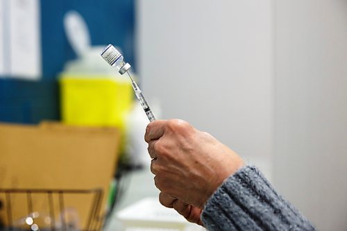 MIKE DEAL / WINNIPEG FREE PRESS
Registered nurse, Irene Par&#xe9;, loads her needles with the Pfizer BioNTech vaccine at her station before the start of her day Friday morning.
Ma Mawi Wi Chi Itata Centre vaccine clinic at 363 McGregor Street, brings in a lot of community support and Indigenous tradition including a morning smudge of the vaccines. The atmosphere of togetherness and one-on-one support has helped many in the area who may be wary of getting the vaccine.
See Melissa Martin story
220121 - Friday, January 21, 2022.