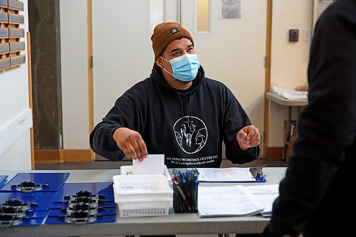 MIKE DEAL / WINNIPEG FREE PRESS
Outreach worker, Adam Wuttunee, helps a client at the check-in table with the forms they need to fill out before getting the vaccine.
Ma Mawi Wi Chi Itata Centre vaccine clinic at 363 McGregor Street, brings in a lot of community support and Indigenous tradition including a morning smudge of the vaccines. The atmosphere of togetherness and one-on-one support has helped many in the area who may be wary of getting the vaccine.
See Melissa Martin story
220121 - Friday, January 21, 2022.