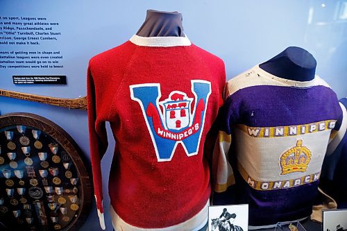 MIKE DEAL / WINNIPEG FREE PRESS
Andrea Reichert, curator at the Manitoba Sports Hall of Fame &amp; Museum, with artifacts from previous winter Olympics.
A 1932 Winnipeg Winnipegs jersey worn by #14, Stan Wagner.
See Brenda Suderman story
220125 - Tuesday, January 25, 2022.
