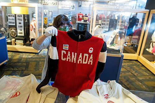 MIKE DEAL / WINNIPEG FREE PRESS
Andrea Reichert, curator at the Manitoba Sports Hall of Fame &amp; Museum, with artifacts from previous winter Olympics.
A sweater worn by an athlete to the 2014 Winter Olympics.
See Brenda Suderman story
220125 - Tuesday, January 25, 2022.