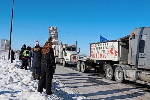 Supporters watch a convoy of trucks pass through Brandon along the Trans Canada Highway on Tuesday morning. This convoy is part of the nation-wide Freedom Rally protest, which aims to halt all federal pandemic restrictions and COVID-19 vaccine mandates. (Kyle Darbyson/The Brandon Sun)