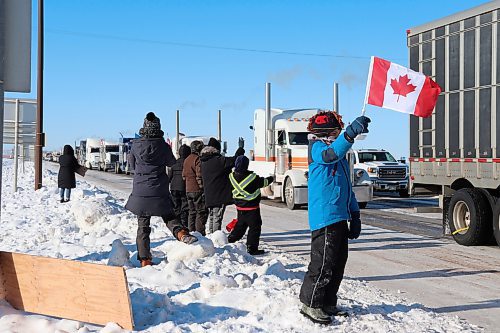 Bystanders watch a convoy of trucks pass through Brandon along the Trans Canada Highway on Tuesday morning. The convoy is bound for Ottawa as part of a protest against federal pandemic restrictions and vaccine mandates. (Kyle Darbyson/The Brandon Sun)