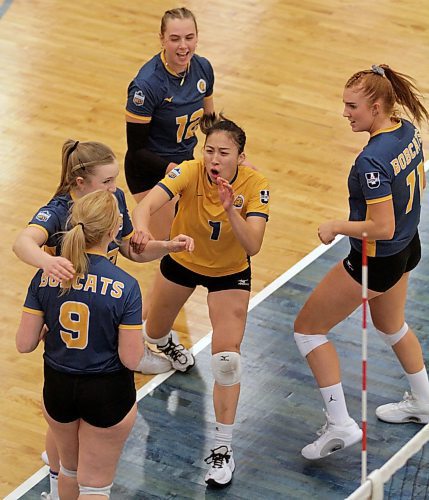 Caitlin Le (1) crosses the Brandon University Bobcats huddle to deliver her signature Caitlin Slap to teammate Alexa Shoults (9) during a Canada West women's volleyball match on Nov. 6. (Thomas Friesen/The Brandon Sun)