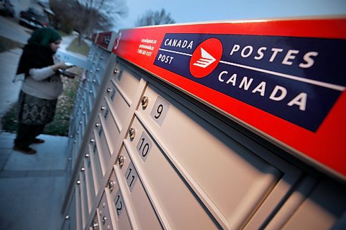 October 26, 2015 - 151026  -  A woman collects mail at a community mailbox Monday, October 26, 2015. Canada Post has suspended installation of these mailboxes until it hears from Canada's new federal government. John Woods / Winnipeg Free Press