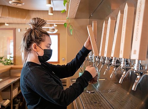 JESSICA LEE / WINNIPEG FREE PRESS

Hunter Brown, a worker at One Sixteen restaurant is photographed serving a beer on January 26, 2022.

Reporter: Eva + Ben S





