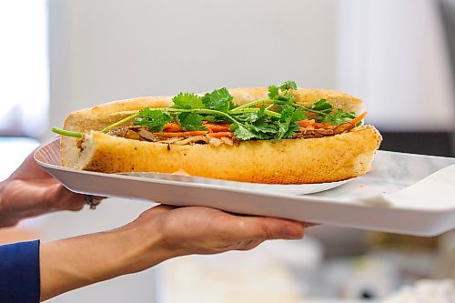 MIKAELA MACKENZIE / WINNIPEG FREE PRESS

Hang Pham holds up a BBQ pork bahn mi at the newly opened Banh Mi Mr. Lee in Winnipeg on Tuesday, Feb. 1, 2022. For Ben Waldman story.
Winnipeg Free Press 2022.