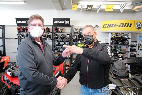 Outgoing Action Power owner Brad Gradidge (right) hands the keys to the business to Curt Amey (left), who took over operations as of Tuesday. (Colin Slark/The Brandon Sun)