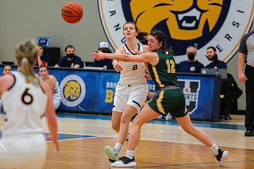 Beth Dueck of the Brandon University Bobcats passes the ball past the University of Regina Cougars Jade Belmore in a Canada West women&#x573; basketball game at the Healthy Living Centre Friday. (Chelsea Kemp/The Brandon Sun)