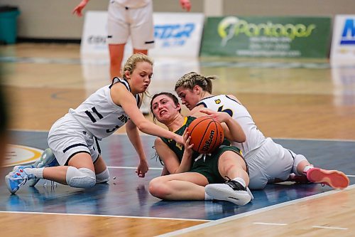 Piper Ingalis, left, and Chelsea Misskey of the Brandon University Bobcats wrestle the University of Regina Cougars Jade Belmore for the ball in a Canada West womenճ basketball game at the Healthy Living Centre Friday. (Chelsea Kemp/The Brandon Sun)