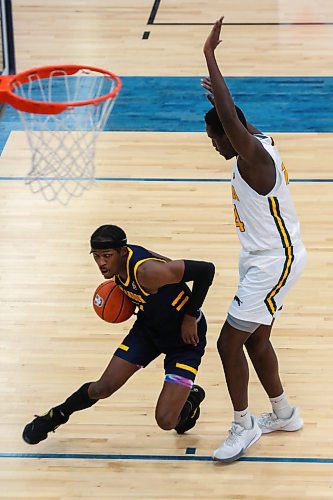 Anthony Tsegakele of the Brandon University Bobcats drives the ball past the University of Regina Cougars Majok Madol in a Canada West men&#x573; basketball game at the Healthy Living Centre Saturday. (Chelsea Kemp/The Brandon Sun)