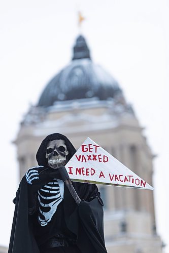 Daniel Crump / Winnipeg Free Press. A  counter protestor dressed as the grim reaper stands at the he trucker convoy protest at the Manitoba legislature Saturday in Winnipeg. February 5, 2022.