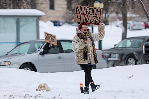 Daniel Crump / Winnipeg Free Press. A counter protestor hols a sign as the trucker convoy protest at the Manitoba legislature continues Saturday in Winnipeg. February 5, 2022.