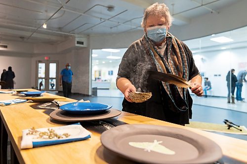 Sweet Medicine Singer Debbie Huntinghawk provides a smudging at the Art Gallery of Southwest Manitoba Thursday during the opening of artist Mary Anne Barkhouse&#x573; exhibit opimihaw. (Chelsea Kemp/The Brandon Sun)