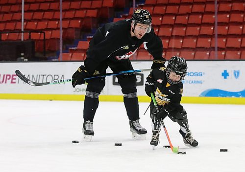 Four-year-old Finn Derlago and Brandon Wheat Kings defenceman Vincent Iorio discuss some strategy after practice on Sunday afternoon. The youngster is the son of assistant coach Mark Derlago. (Perry Bergson/The Brandon Sun)