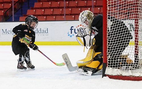 Four-year-old Finn Derlago comes in on Brandon Wheat Kings goalie Ethan Kruger after the Western Hockey League team&#x2019;s practice on Sunday afternoon. The youngster, who is the son of assistant coach Mark Derlago, is popular with players, with Vincent Iorio and Jake Chiasson each spending a lot of time with him after he came on the ice. (Perry Bergson/The Brandon Sun)
