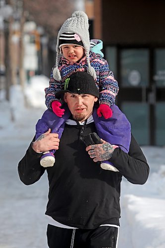 14022021
Derek Baker gives his three-year-old daughter Keight a piggyback ride in downtown Brandon on Monday. (Tim Smith/The Brandon Sun)