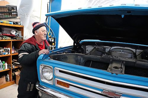 Lothar Weber pops the hood of his 1968 Chevrolet C30 truck on Wednesday morning. (Kyle Darbyson/The Brandon Sun)