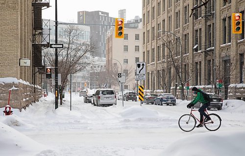 JESSICA LEE / WINNIPEG FREE PRESS

A person bikes through the Exchange District on February 18, 2022.

