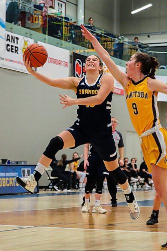 Brandon University Bobcats Adrianna Proulx leaps past the University of Manitoba Bisons Autumn Agar in a Canada West women&#x573; basketball game at the Healthy Living Centre Friday. (Chelsea Kemp/The Brandon Sun)