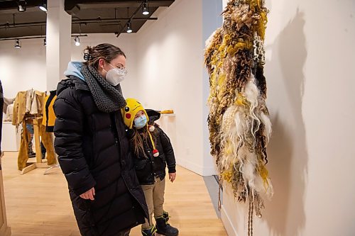 Mike Sudoma / Winnipeg Free Press
Artist, Maureen Winnicki Lyons&#x2019; children, Teresa Lyons (left) and Duncan Campbell (right) look at their mothers tunic on display at the C2 Centre for Craft as part of the One Year Outfit Challenge Exhibition Friday evening
February 18, 2022