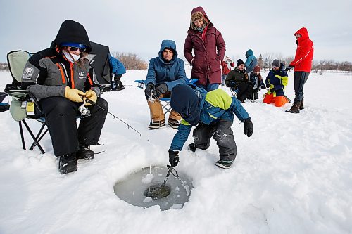JOHN WOODS / WINNIPEG FREE PRESS
Liam, 6, cleans out a fishing hole as from left, Emily MacDonald, and his father and mother, Max Kreuser and Micheline Marchildon, and other family and friends enjoy a day of fishing at Lockport, Sunday, January 20, 2022. There is a licence free Winter Family Fishing Weekend happening this weekend. Emily MacDonald has been coming ice fishing with her parents since she was a baby.

Re: standup