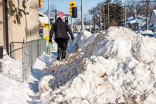 MIKAELA MACKENZIE / WINNIPEG FREE PRESS

Pedestrians struggle to navigate the almost non-existent sidewalk, which has been taken over by snowbanks, on Saint Matthews Avenue in Winnipeg on Tuesday, Feb. 22, 2022. For Malak story.
Winnipeg Free Press 2022.