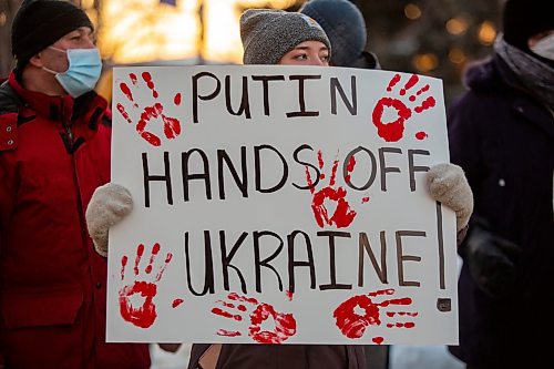 Adelina Krugovykh holds a sign in support of Ukraine in front of Brandon City Hall Friday. Ukraine was invaded by Russian forces Thursday. (Chelsea Kemp/The Brandon Sun)