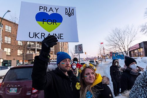 Cody Lawrence, left, and Mariya Kabashko gather with other community members in front of Brandon City Hall Friday in support of Ukraine. The country was invaded by Russian forces Thursday. (Chelsea Kemp/The Brandon Sun)