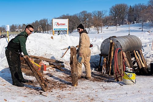 Eric Eissner, left, and Lucas Tufts chop wood to heat water for the ice resurfacer at the Rink The River Shinny Tournament  Saturday in Souris. (Chelsea Kemp/The Brandon Sun)