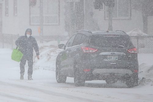 Daniel Crump / Winnipeg Free Press. A person walks to their car parked on Arlington street as heavy and blowing snow make for treacherous road conditions Saturday afternoon. March 12, 2022.