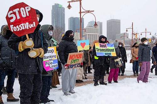 Daniel Crump / Winnipeg Free Press. People hold signs during a climate rally organized by Manitoba Energy Justice Coalition. Around 50 people attended the rally in front of the Canadian Museum for Human Rights at noon on Saturday. March 12, 2022.