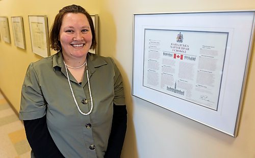 Westman Immigrant Services community outreach manager Hannah Holt stands in front of the Canadian Charter of Rights and Freedoms Friday. (Chelsea Kemp/The Brandon Sun)