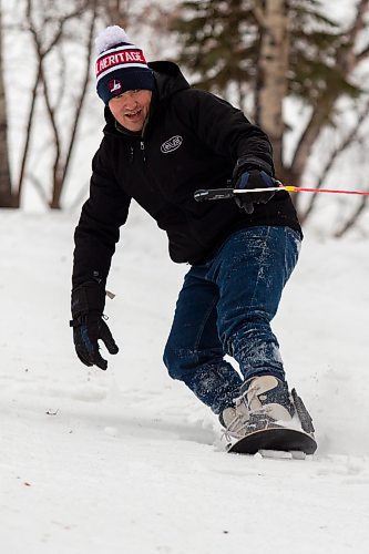 Matthew Reimer is pulled on a snowboard behind a horse during a fundraiser at Turtle Mountain Bible Camp Saturday. (Chelsea Kemp/The Brandon Sun)