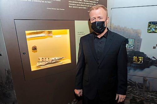 RCA Museum director Andrew Oakden poses with a piece of one of the aircraft used in the 9/11 attacks featured in the travelling exhibition Mission: Afghanistan Wednesday. (Chelsea Kemp/The Brandon Sun)