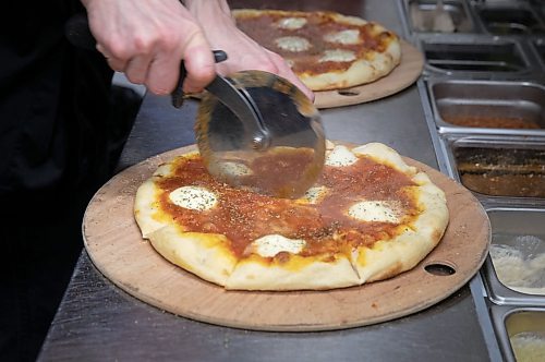 JESSICA LEE / WINNIPEG FREE PRESS

Sous chef Houston Price cuts a Margherita pizza on March 15, 2022 at Little Nana&#x2019;s Italian Kitchen.

Reporter: Dave
