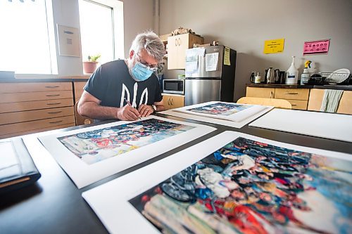MIKAELA MACKENZIE / WINNIPEG FREE PRESS

Local artist Michael Boss, who is selling prints with proceeds going to the Ukrainian Red Cross, signs prints at the Martha Street Studio in Winnipeg on Friday, March 18, 2022.  For Alan Small story.
Winnipeg Free Press 2022.