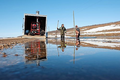 23032022
Jim Chessman and Fred Willman with the Rural Municipality of Whitehead work to clear ice from a culvert so melt water drains from next to a grid road west of Brandon on Wednesday.   (Tim Smith/The Brandon Sun)